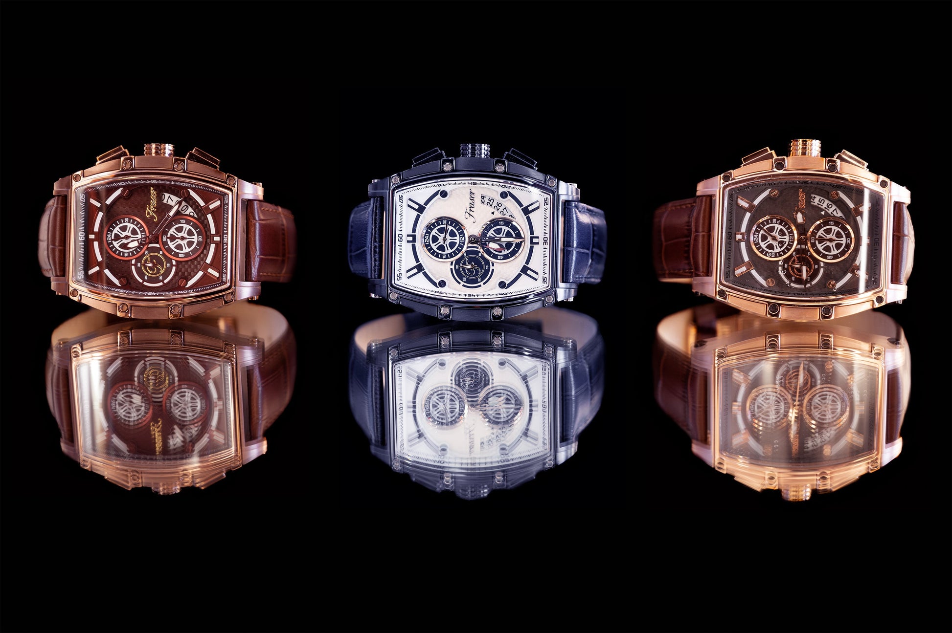 Three luxury watches with reflective surfaces on a black background