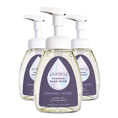 Three bottles of Puracy foaming hand wash on a green background.